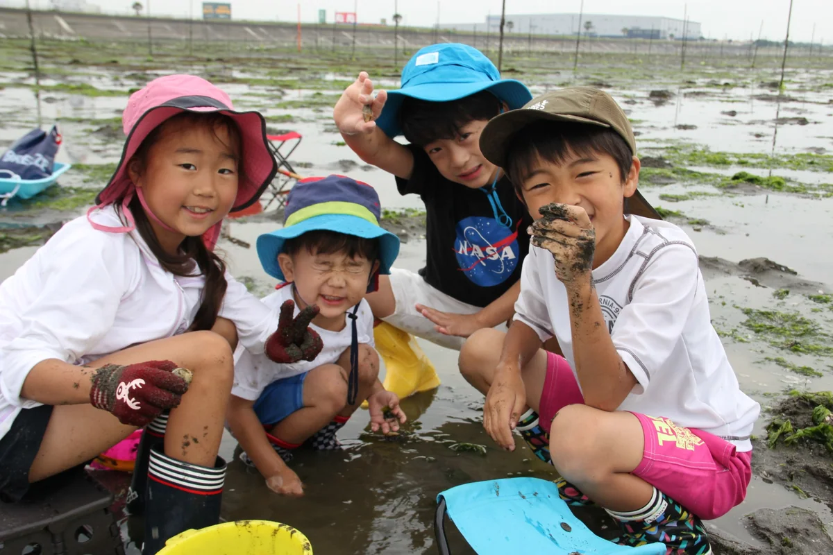 採れた貝を見せて笑顔になる子どもたち