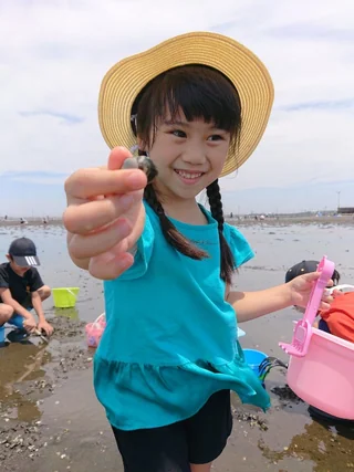 採った貝を手に持って見せる子ども