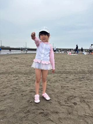 干潟で片手を上げる子ども
