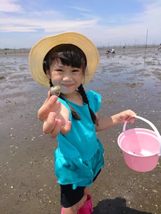 採った貝を前に差し出す子ども