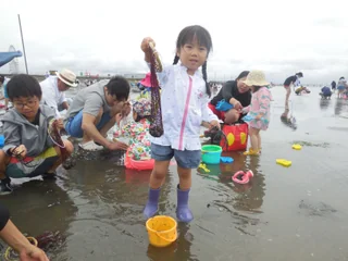 周囲の来場者と潮干狩りを楽しむ子ども