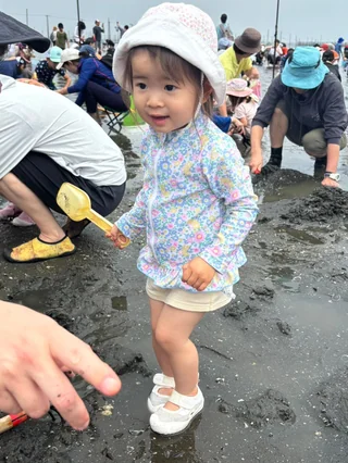 白い帽子をかぶって笑顔を見せる幼児