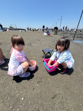 ピンクのバケツを囲んでしゃがむ子ども2人