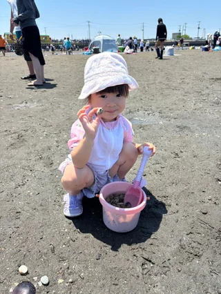 貝の入ったピンクのバケツを見せる子ども