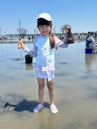 干潟で両手を広げる子ども